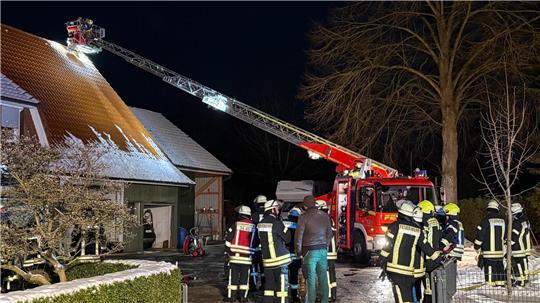 Einsatzkräfte der Feuerwehren löschen, kontrollieren und überprüfen die vom Feuer betroffenen Bereiche im Bereich der Scheune des Gebäudes in Oldendorf.