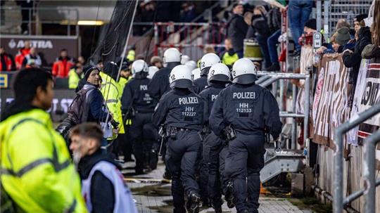 Einsatzkräfte der Polizei laufen auf den Fanblock der Hannoveraner zu.