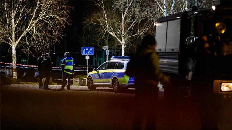 Einsatzkräfte der Polizei stehen am abgesperrten Tatort.