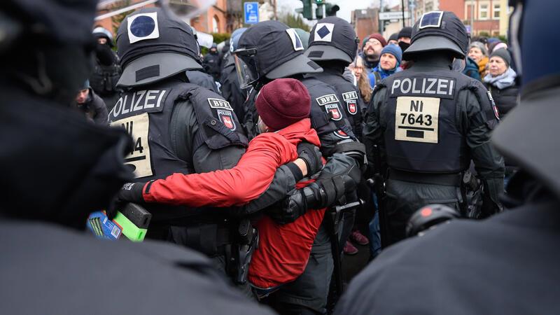 Querdenker-Demo und Gegenprotest: Polizei in Göttingen greift ein Einsatzkräfte der Polizei tragen einen Demonstranten davon.