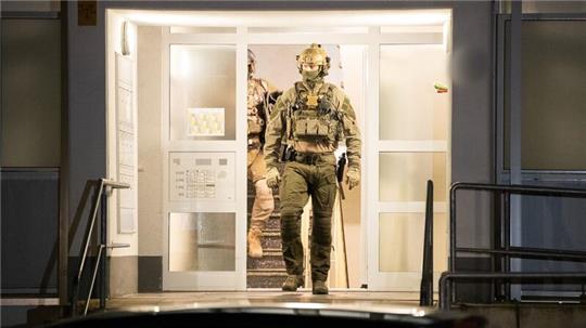 Einsatzkräfte der Polizei verlassen nach einer Durchsuchung ein Gebäude in Düsseldorf.