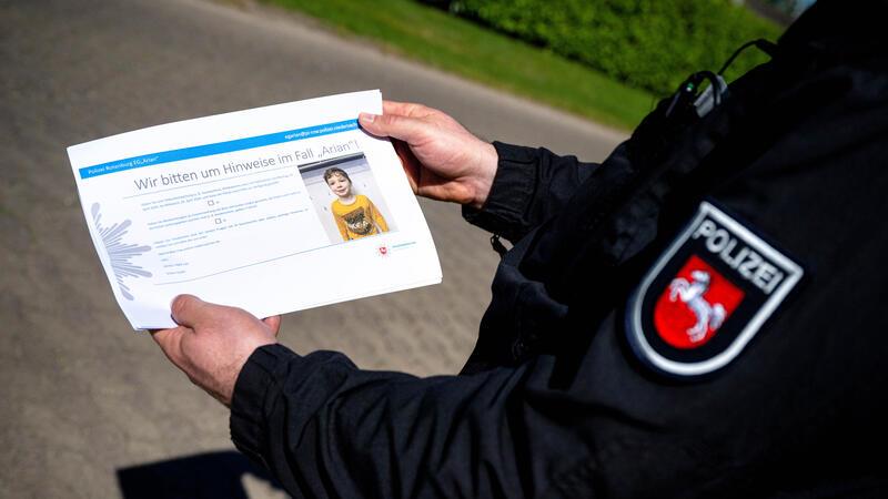 Einsatzkräfte der Polizei verteilen bei einer Anwohnerbefragung im Ortsteil Gräpel in der Nähe von Elm Hinweisblätter.