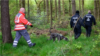 Einsatzkräfte des Deutschen Roten Kreuzes sind mit einem Suchhund in einem Waldstück im Einsatz. Von dem vermissten sechs Jahre alten Jungen aus dem niedersächsischen Bremervörde fehlt noch immer jede Spur. 