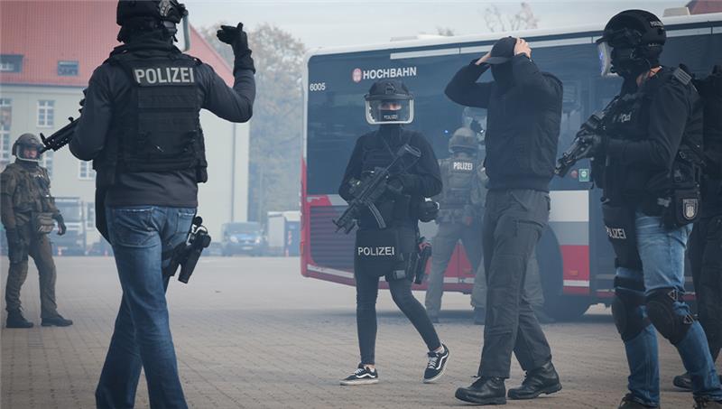 Einsatzkräfte des Mobilen Einsatzkommandos (MEK) und des Spezialeinsatzkommandos (SEK) der Polizei Hamburg demonstrieren ein mögliches Einsatzszenario zur Bewältigung einer Geisellage in einem Bus in Winterhude. Foto: Christian Charisius/dpa