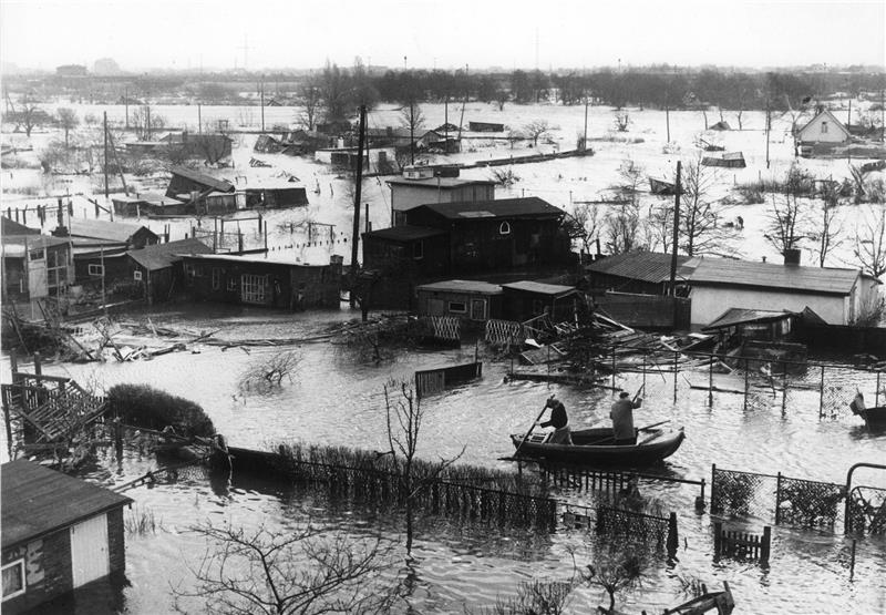 Zeitzeugen erinnern sich an Schrecken und Abenteuer der Sturmflut Einsatzkräfte fahren mit einem Boot durch ein überschwemmtes Wohnviertel in Hamburg. Foto: dpa
