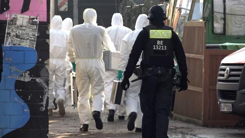 Zwei Männer bei RAF-Fahndung in Berlin festgenommen Einsatzkräfte gehen auf ein Grundstück.