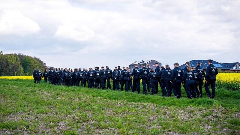 Vermisster Sechsjähriger: Überwachungskamera zeigt Arians Verschwinden Einsatzkräfte laufen über einen Feldweg auf den Wald zu.