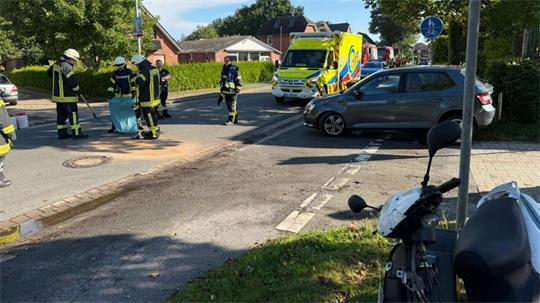Einsatzkräfte sichern die Unfallstelle an der Langenstraße Ecke Dr.-Hermann-Plettrichs-Weg, wo ein Motorroller (im Bildvordergrund) und ein Auto (im Bildhintergrund) zusammengestoßen sind. 