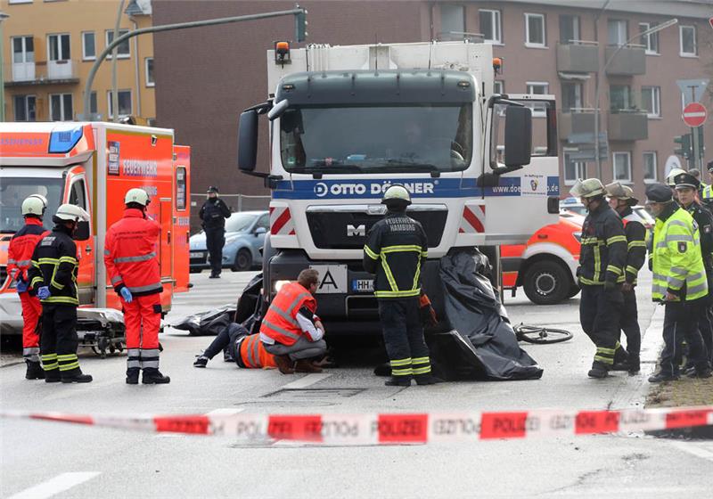 Einsatzkräfte sind nach einem tödlichen Verkehrsunfall an der Unfallstelle im Einsatz. Bei einem Verkehrsunfall in Hamburg-Wandsbek ist ein Radfahrer von einem Müllwagen erfasst und tödlich verletzt worden. Foto: Bodo Marks/dpa