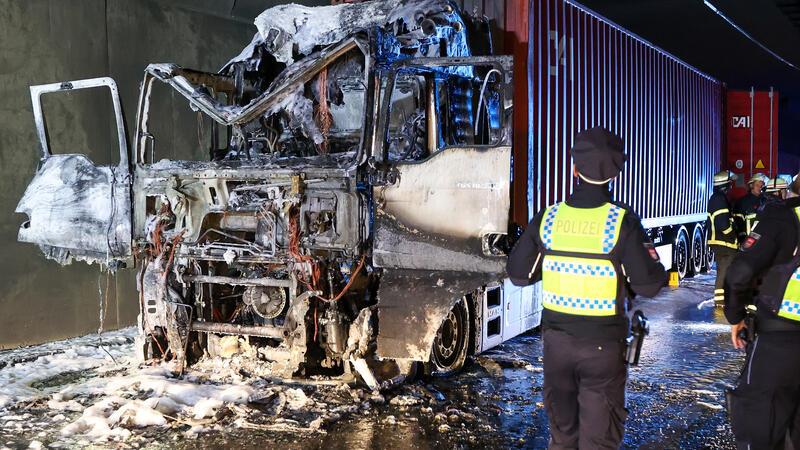 Stau bei Elbtunnel nach Lkw-Brand - eine Röhre noch gesperrt Einsatzkräfte stehen im Elbtunnel an einer ausgebrannten Lkw-Zugmaschine. Wegen des Brandes in der Röhre des Elbtunnels in Fahrtrichtung Norden war der Hamburger Elbtunnel zeitweise gesperrt.