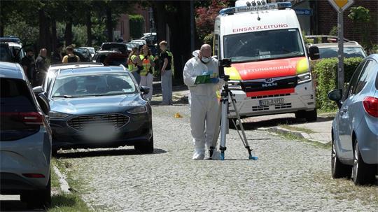 Einsatzkräfte und Spurensicherung stehen auf einer Straße in Stade.