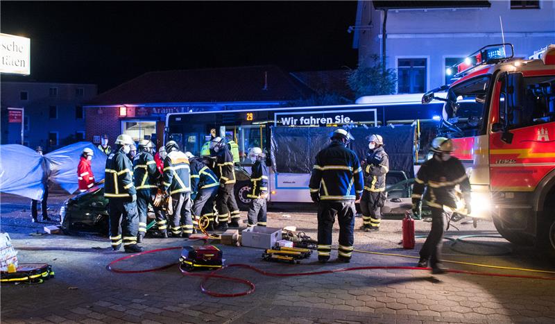 Einsatzkräfte versorgen im Stadtteil Kirchsteinbek zwischen einem Auto und einem Linienbus die Verletzten. Elf Menschen sind bei einem Unfall mit einem Kleinwagen und einem Linienbus im Hamburger Stadtteil Billstedt verletzt worden. (zu dpa: «Autofahrer nach Kollision mit Bus in Lebensgefahr - elf Verletzte») Foto: Daniel Bockwoldt/dpa