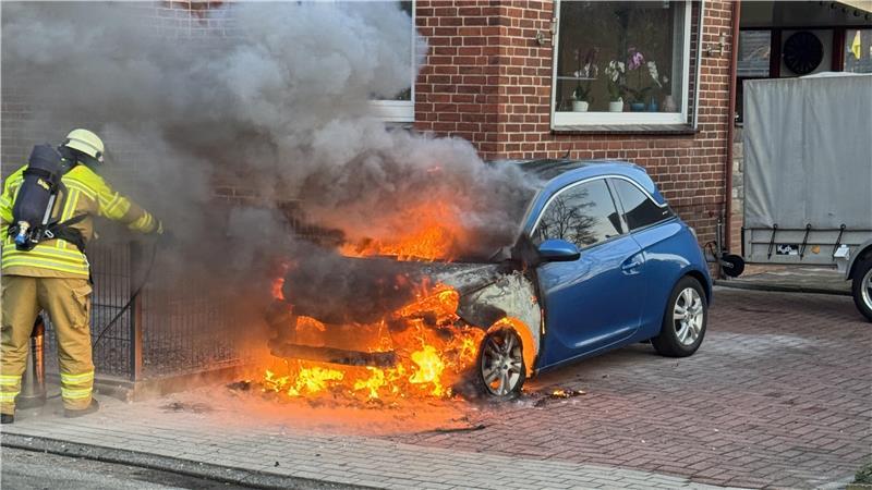 Ein Feuerwehrmann löscht ein brennendes Auto in Stade. 
