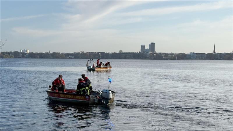 Einsatzkräfte von Feuerwehr, DLRG und Polizei suchen auf der Außenalster nach einer möglicherweise vermissten Person.
