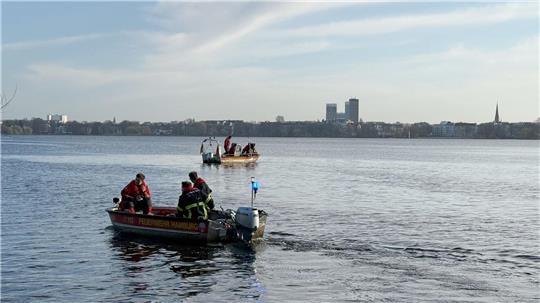 Einsatzkräfte von Feuerwehr, DLRG und Polizei suchen auf der Außenalster nach einer möglicherweise vermissten Person.