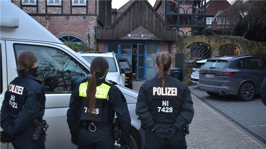Einsatzkräfte vor einem Durchsuchungsobjekt.