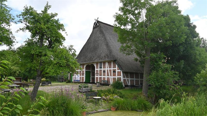 TV-Kommissarin „wohnt“ hier: Bekanntestes Altländer Bauernhaus wird saniert Einzigartiges Ensemble: Blick auf das Haupthaus des Harmshofes in Königreich, vorne rechts ist der alte Küchen- und Waschgraben mit gepflasterter Pferdetränke und Wagenwäsche zu sehen.