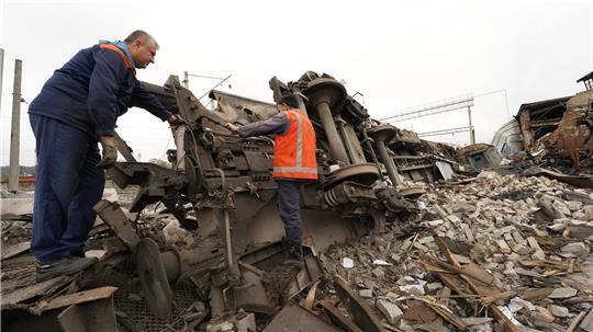 Eisenbahner räumen die Trümmer auf, nachdem ein Eisenbahndepot bei einem, mutmaßlich russischen, Raketenangriff zerstört wurde.