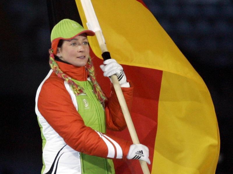 Eisschnelläuferin Claudia Pechstein trägt 2006 bei der Abschlussfeier der Olympischen Winterspiele in Turin die deutsche Fahne. Foto: Matthias Schrader/dpa