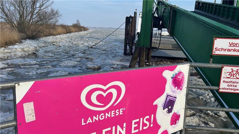 Eiszeiten treffen aufeinander: Sommerwünsche und Winterwetter am Fähranleger.