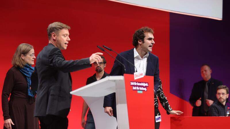 Spitzenduo und Programm: Linke bereit für Europawahlkampf Eklat auf offener Bühne: Bijan Tavassoli (r) nutzte seine Bewerbungsrede für eine Beschimpfung der Linken und eine Lobrede auf Sahra Wagenknecht - und erklärte zum Abschluss seiner Rede seinen Parteiaustritt.