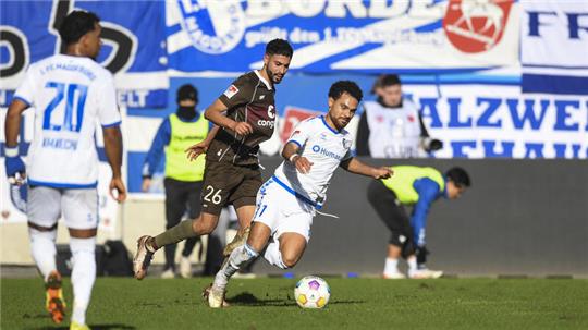 Elias Saad von St. Pauli (M) und Herbert Bockhorn von Magdeburg kämpfen um den Ball.