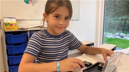 Elina (8) genießt es, vor Unterrichtsbeginn schon mit den anderen gemeinsam zu spielen und hat sich ein Logik-Spiel geschnappt.
