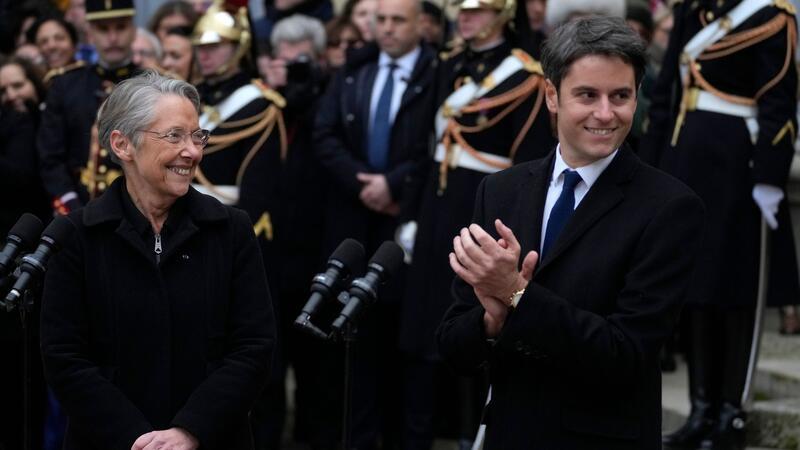 Elisabeth Borne, scheidende Premierministerin von Frankreich, lächelt dem neu ernannten Premierminister Gabriel Attal nach der Übergabezeremonie in Paris zu.
