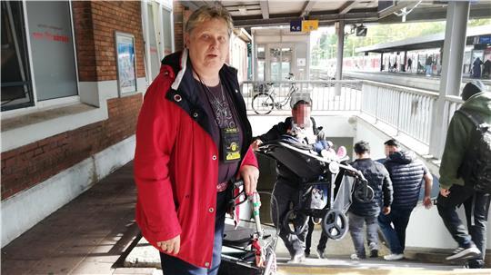 Elke Borchmann muss mit ihrem Rollator die Treppe runter, weil der Fahrstuhl kaputt ist. Der Mann im Hintergrund hilft gerade einer Mutter, die ihren Kinderwagen alleine nicht hätte tragen können.