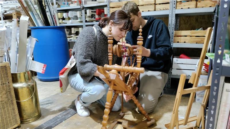 Dirk und Marinas Flohmarkthalle in Stade: Ein Paradies für Trödel-Fans Ella Weilandt und Florian Hermann prüfen ein Spinnrad in der Handarbeitsabteilung.