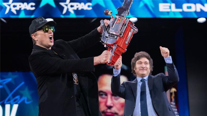 Elon Musk hält eine Kettensäge, die er vom argentinischen Präsidenten Javier Milei (r) erhalten hat.