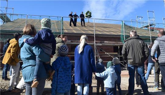 Eltern und Kinder sind Gast beim Weihen des Hauses durch die Zimmermänner.