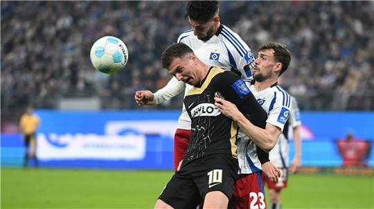 Elversbergs Fisnik Asllani (vorn, l) wird von den beiden HSV-Spieler Ludovit Reis und Jonas Meffert geblockt.