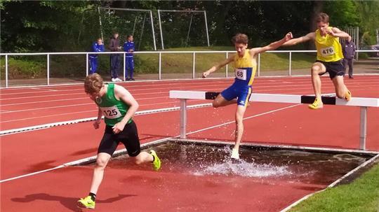 Emil Keppler springt über einen Balken in einen Wassergraben auf einer Tartanbahn.