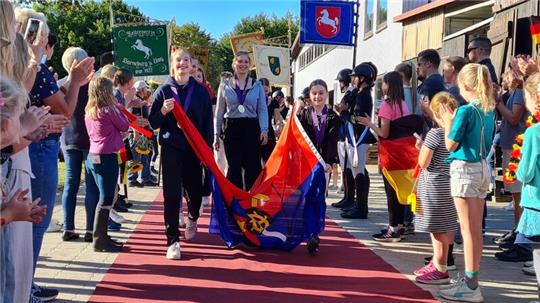 Das Juniorteam Fredenbeck läuft über einen roten Teppich, nachdem es die Europameisterschaft gewonnen hat. 