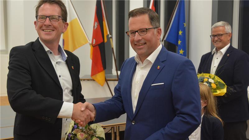 Ende des Kampfs um den Landratsposten: Wahlsieger Kai Seefried (rechts) und sein Herausforderer Björn Protze nach der Wahl 2021. Im Hintergrund steht Seefrieds Vorgänger Michael Roesberg.