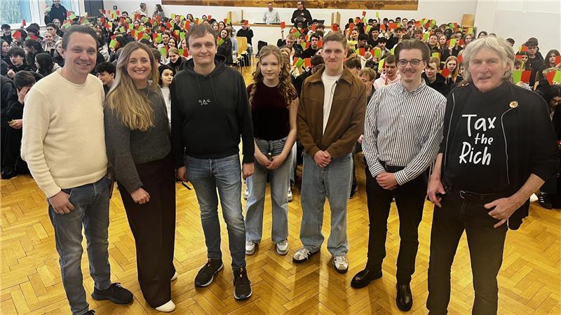 Enrico Bergmann (FDP), Elena Brückner (SPD), Sebastian Klinge (CDU), die Moderatoren Lynette Riedel und Adrian Gaus, Tim Evers (Grüne) und Michael Quelle (Linke, von links) mit Schülerpublikum in der Aula der IGS.