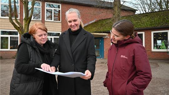 Enttäuscht von Rat und Verwaltung (von links): Meike Booken, Sabine Folster und Katrin Kruppa studieren die Pläne für den Neu- und Umbau der Grundschule Horneburg.