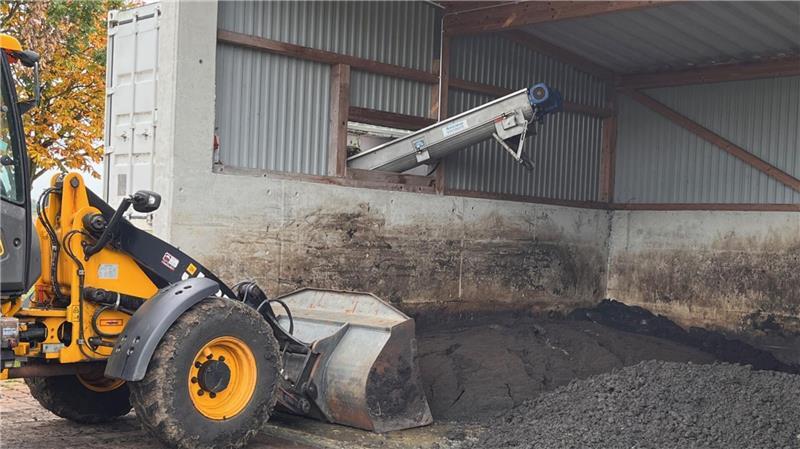 Entwässert und gepresst krümelt der Klärschlamm wie trockener, dunkler Sand auf einen Haufen. Der Schlamm wird durch ein Entsorgungsunternehmen abgeholt und als Sondermüll verbrannt.