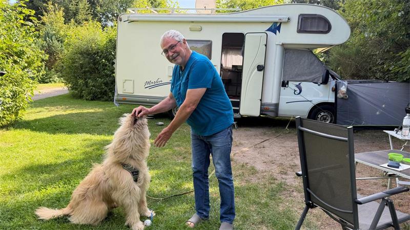 Camping in Sauensiek: Was verschlägt Urlauber in das kleine Dorf? Er will nur spielen: Bernd Brunner aus Schwalmtal mit seinem deutschen Schafspudel Bo.
