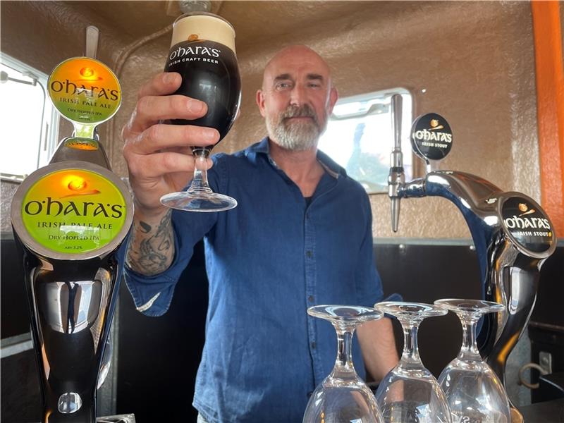 Erik Jablonski hält das erste gezapfte Bier in seinem umgebauten Pferdeanhänger „The Drunken Donkey“ in die Höhe. Foto: Ahrens