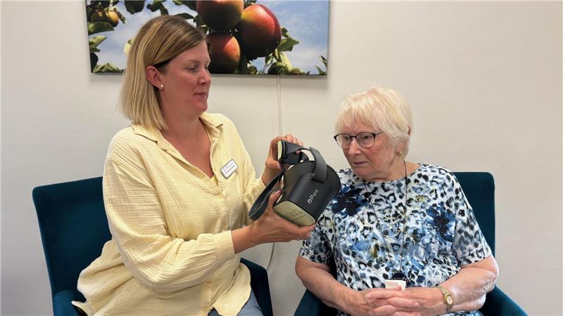 Erika Hermann reist mit der VR-Brille gleich nach Hamburg. Einrichtungsleiterin Ann-Christin Martens hilft ihr.