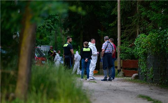 Ermittler der Polizei arbeiten am Tatort. Auf benachbarten Wohngrundstücken bei Bienenbüttel sind drei Tote gefunden worden. Foto: Philipp Schulze/dpa