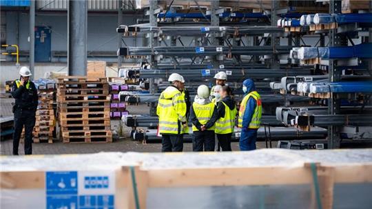 Ermittler und Polizisten stehen nahe der Unglücksstelle am Hamburger Hafen.