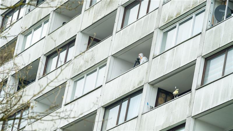 Ermittler untersuchen einen Balkon des Hochhauses. 
