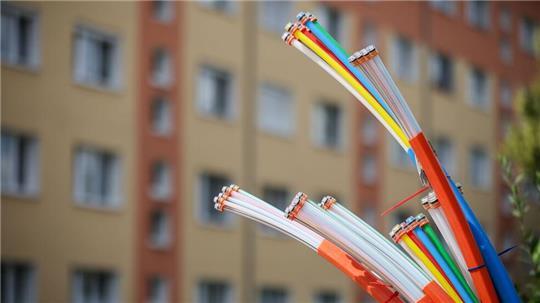 Erst mal angeschlossen, bieten sie Highspeed-Internet: Glasfaserkabel, die aus dem Sockel eines Schaltschranks herausragen.