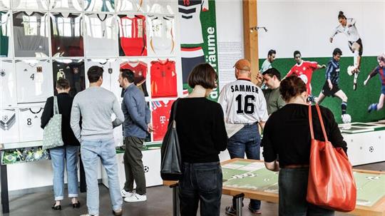 Erste Besucher sehen sich im Auswanderermuseum Ballinstadt die Ausstellung „Fußball & Migration“ an.