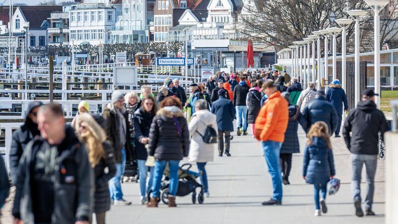 Erste Besucher sind am Samstagvormittag auf der Promenade von Travemünde unterwegs.
