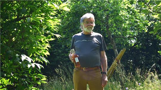 Ertrag der eigenen Ernte: Der Fredenbecker Wolfgang Weh mit einer Flasche Saft von seinem Apfelbaum. Der Apfelbaum hat auch etwas mit seiner Zauberformel zu tun.