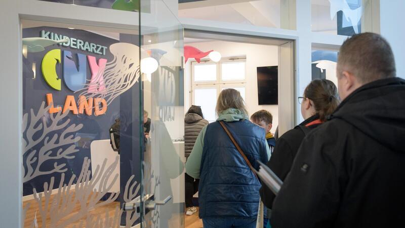 Freie Plätze beim Kinderarzt: Eltern stehen wie im Schlussverkauf Schlange Es kann losgehen: Die wartenden Eltern werden nach und nach an den Empfangstresen der Kinder- und Jugendarztpraxis Cuxland gebeten.